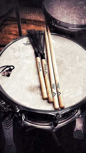 Photo d'une caisse claire avec des baguettes et balais de marque Vater